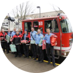 portland toy and joy maker firefighters handing out Christmas gifts